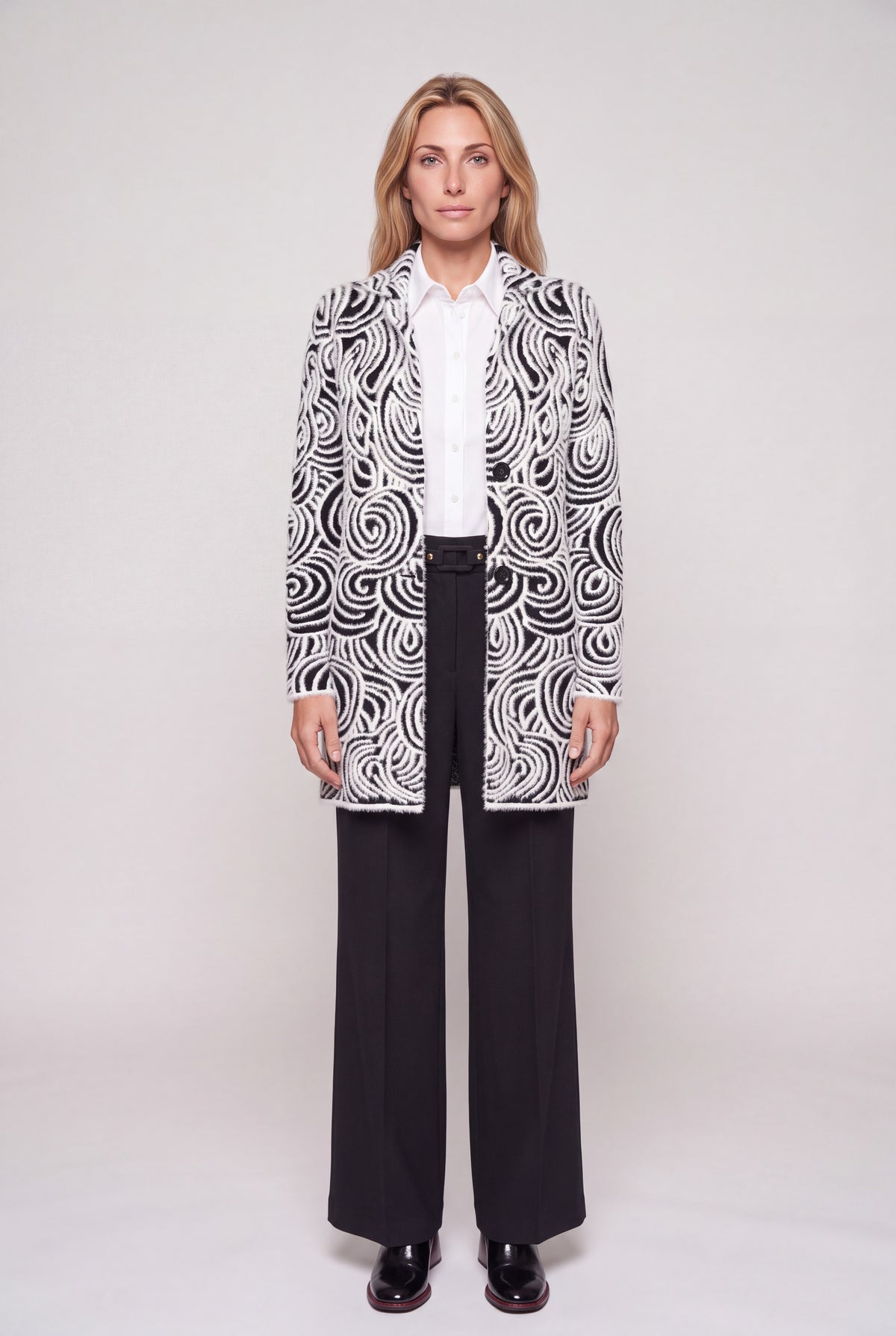 Cappotto jacquard bianco e nero con motivo a onde e spirali, collo a revers e due bottoni