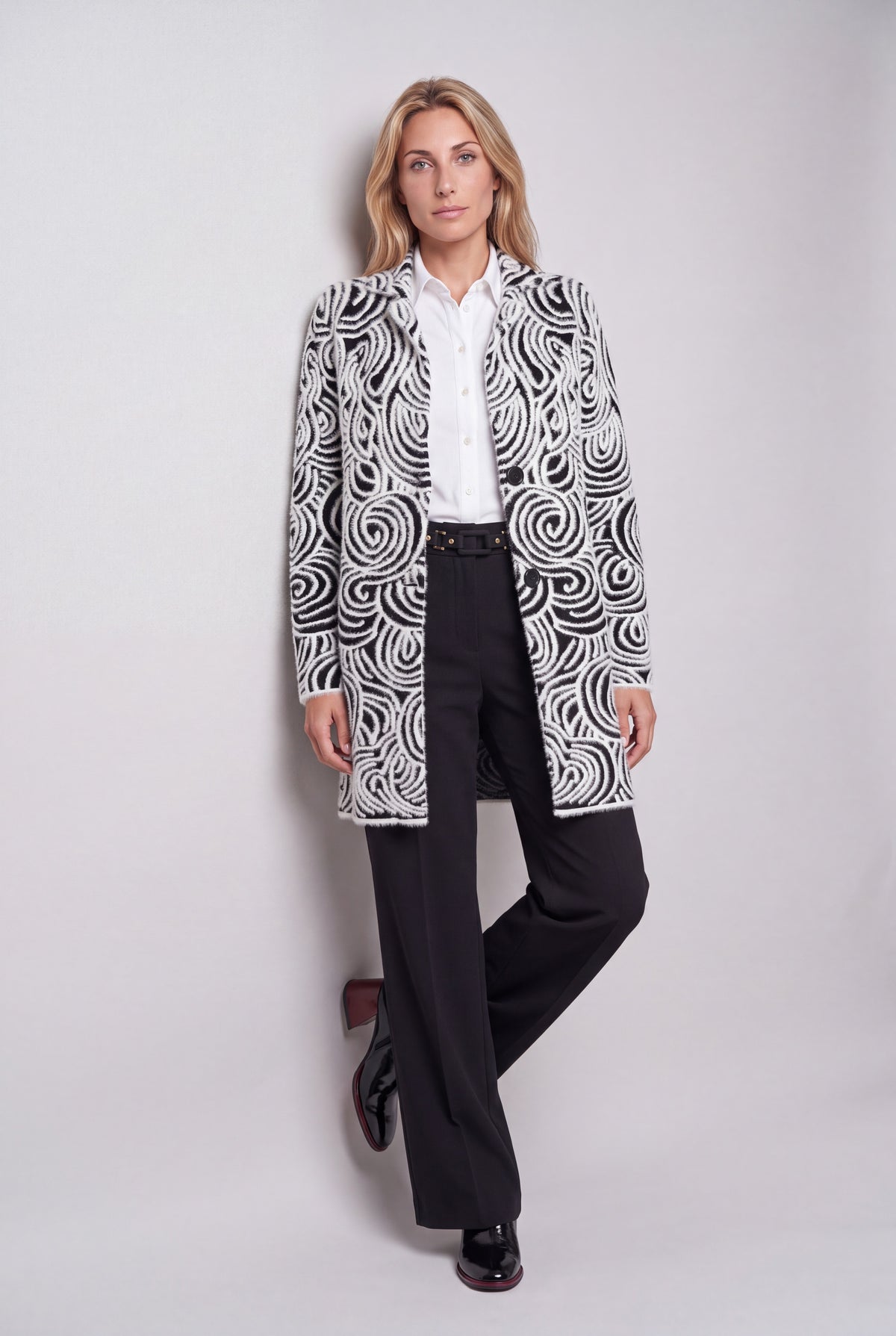 Cappotto jacquard bianco e nero con motivo a onde e spirali, collo a revers e due bottoni