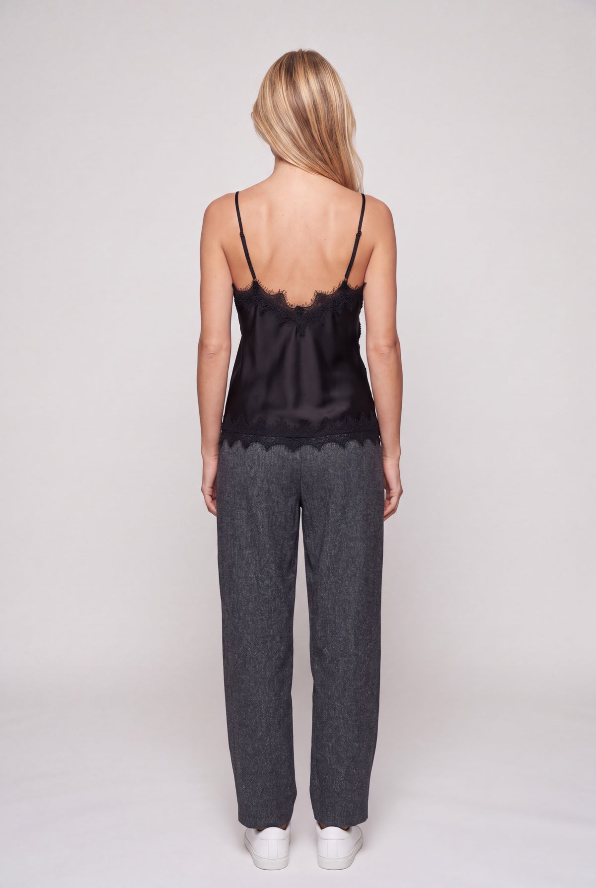 Top lingerie in raso nero con bordo di pizzo smerlato e bretelline sottili su manichino