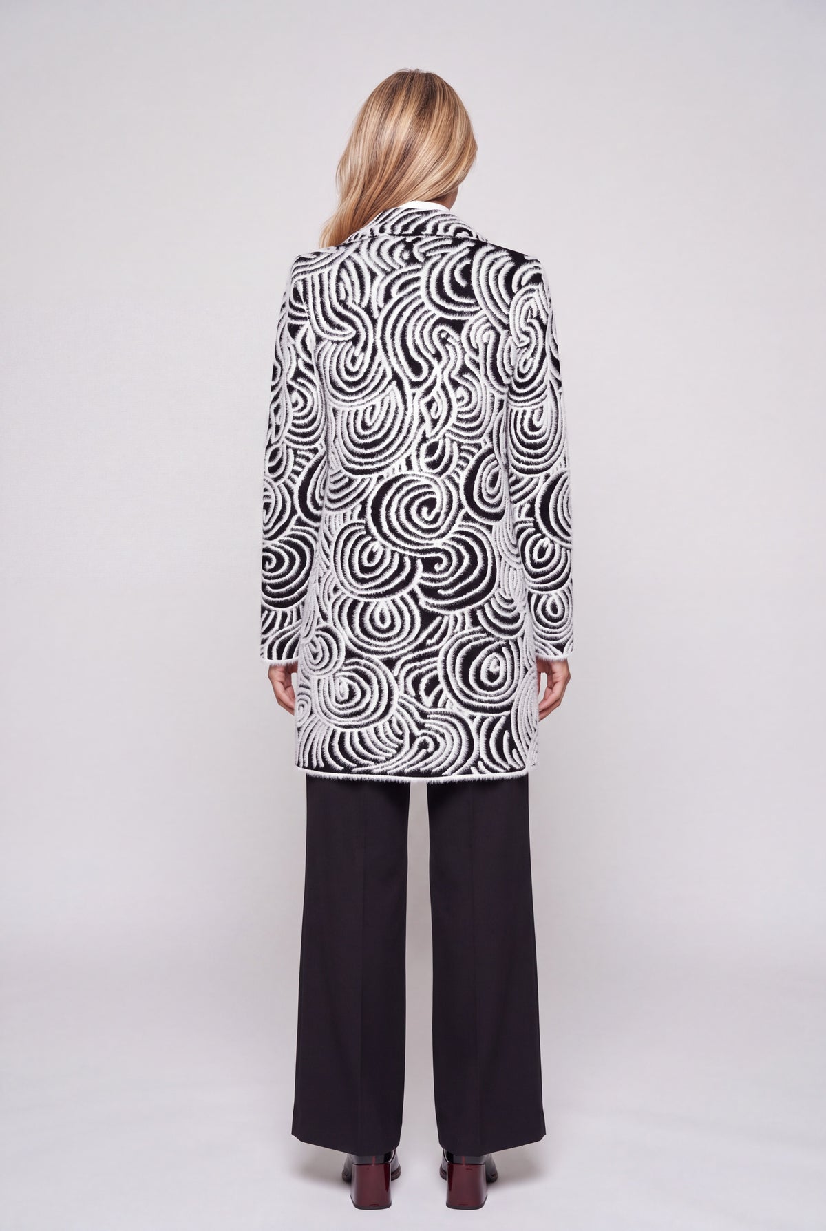 Cappotto jacquard bianco e nero con motivo a onde e spirali, collo a revers e due bottoni