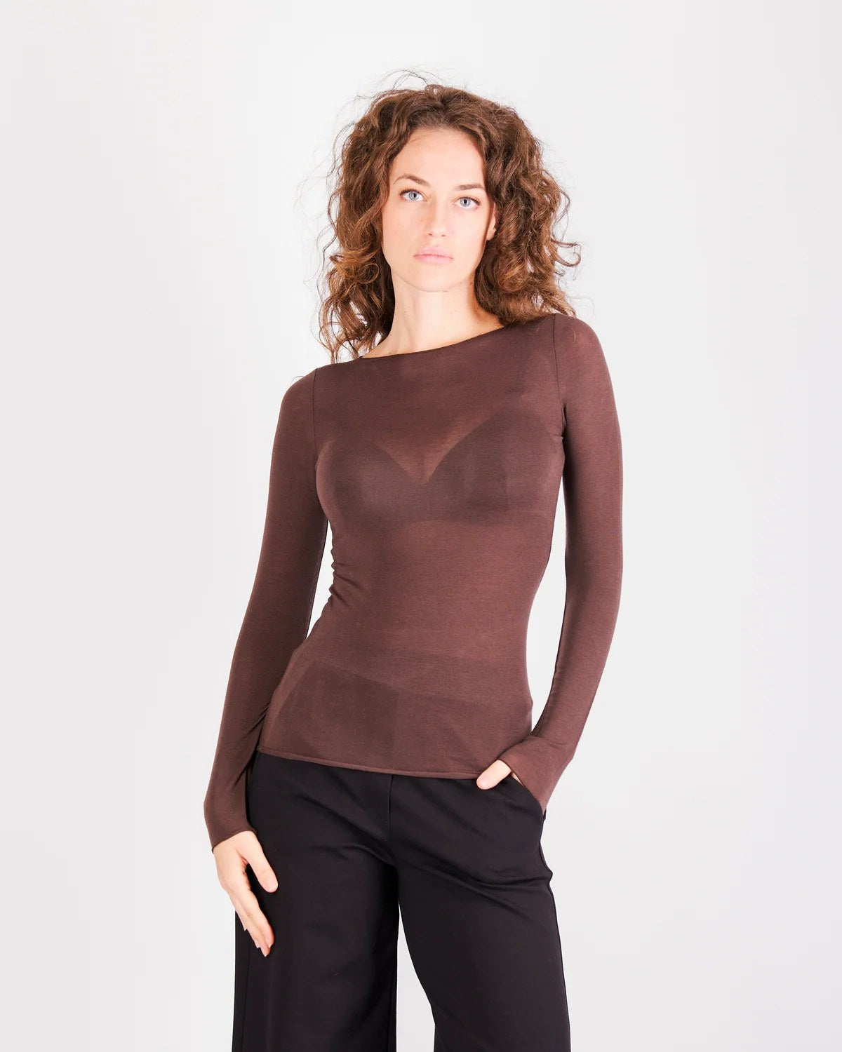 Donna indossa maglia ultraleggera scollo a barchetta blu semitrasparente con pantaloni neri a gamba larga