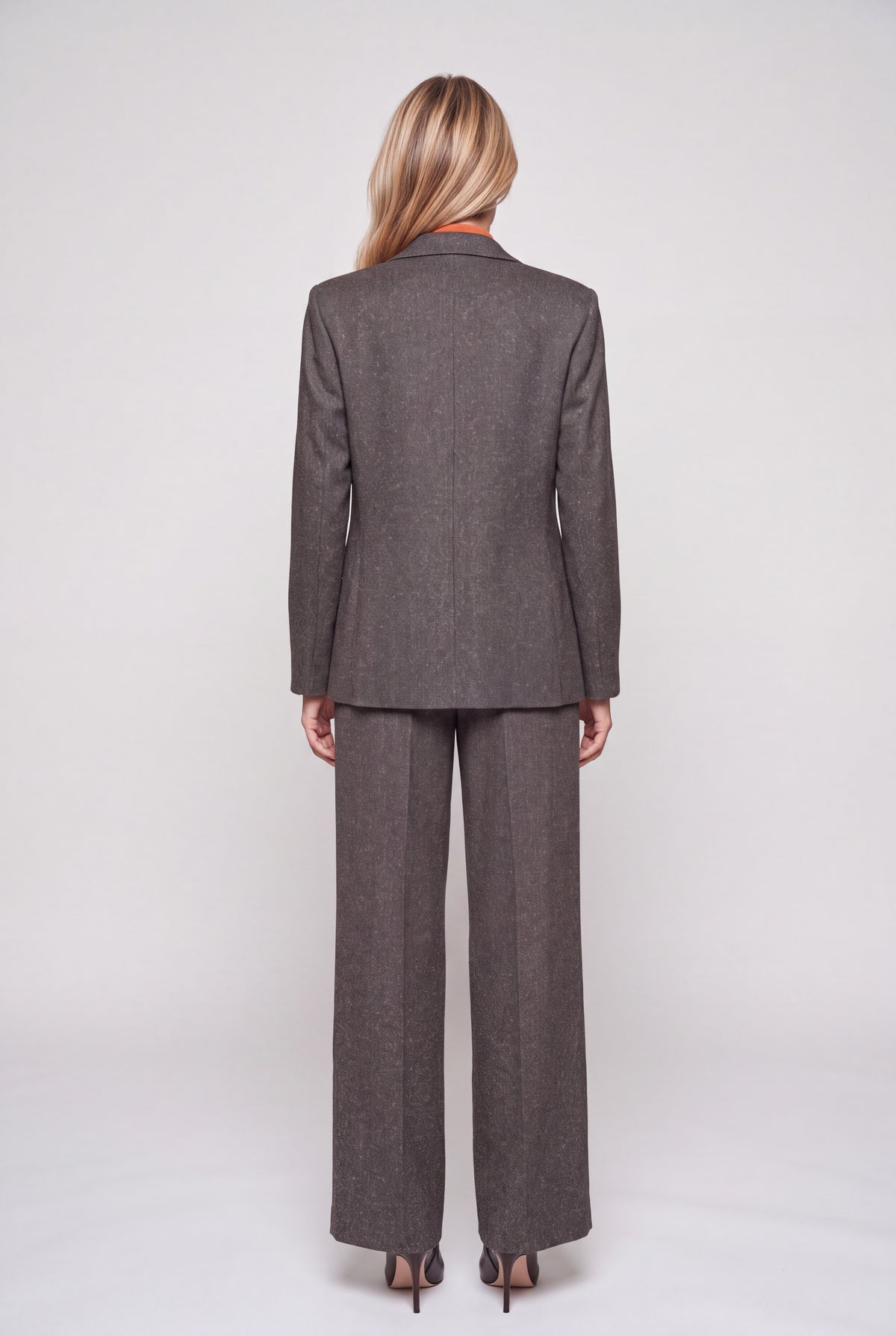 Giacca monopetto tweed color moro con revers a lancia e bottone ricoperto, indossata su completo coordinato