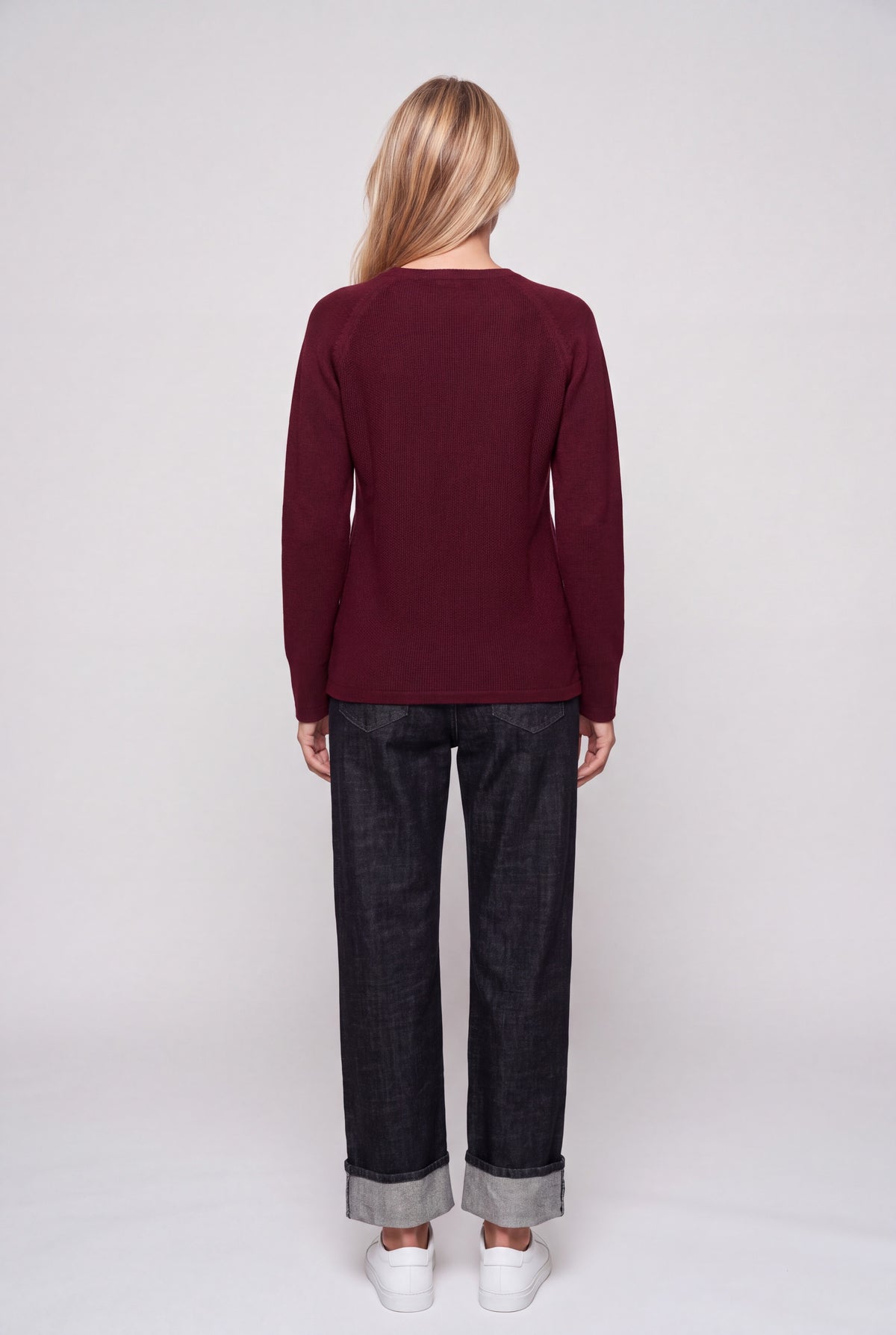 Maglia girocollo donna in punto riso color bordeaux con manica raglan, indossata con jeans scuri