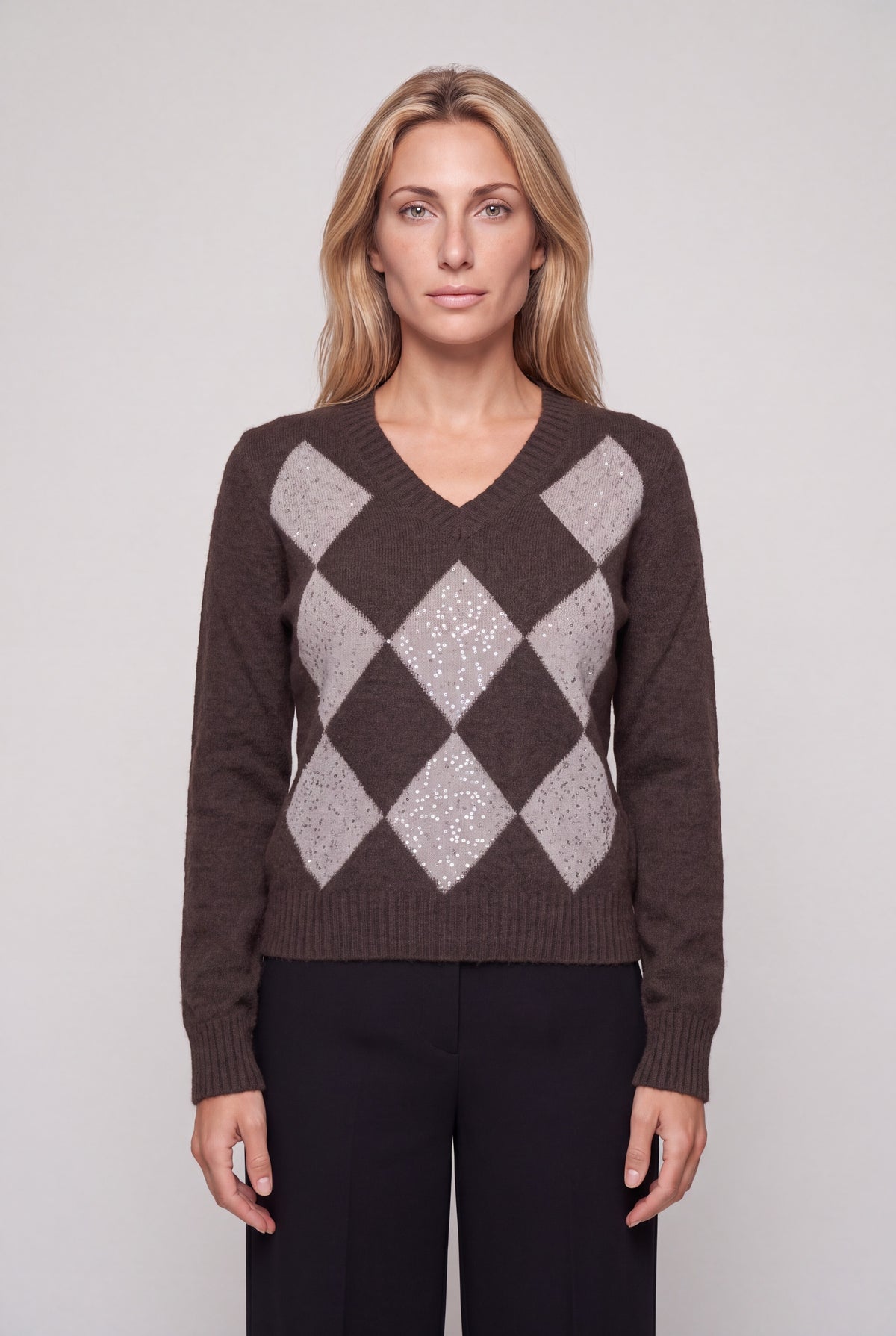 Maglia scollo a V con rombi marroni e paillettes, motivo argyle, indossata da modella