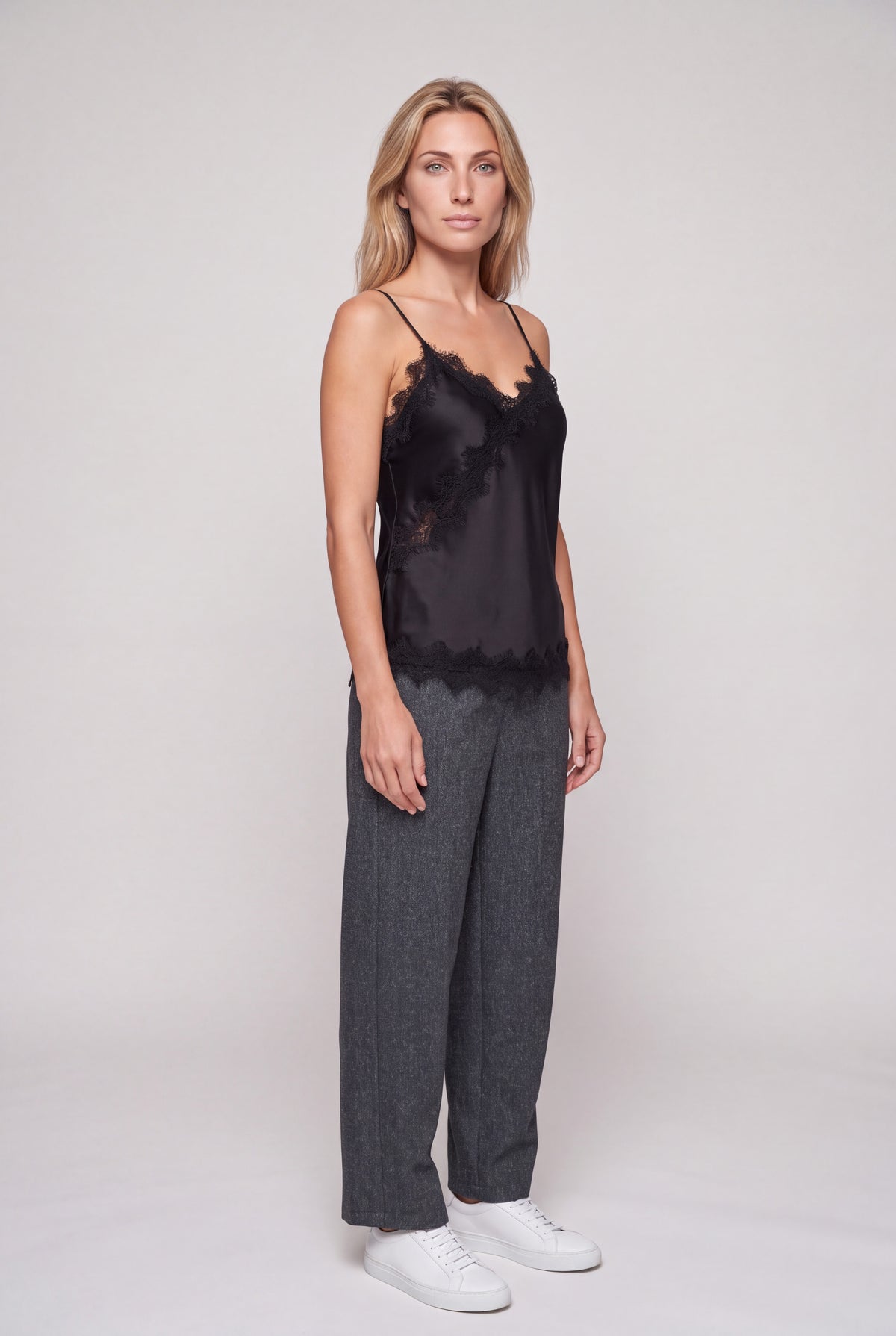 Top lingerie in raso nero con bordo di pizzo smerlato e bretelline sottili su manichino