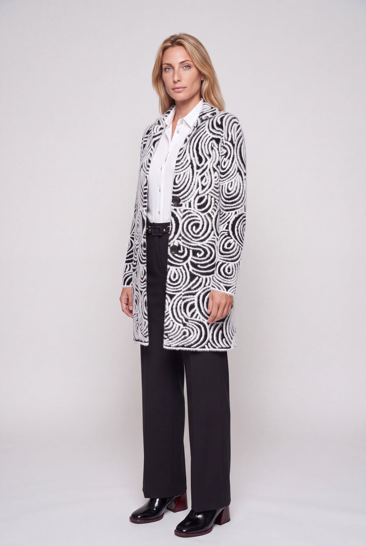 Cappotto jacquard bianco e nero con motivo a onde e spirali, collo a revers e due bottoni