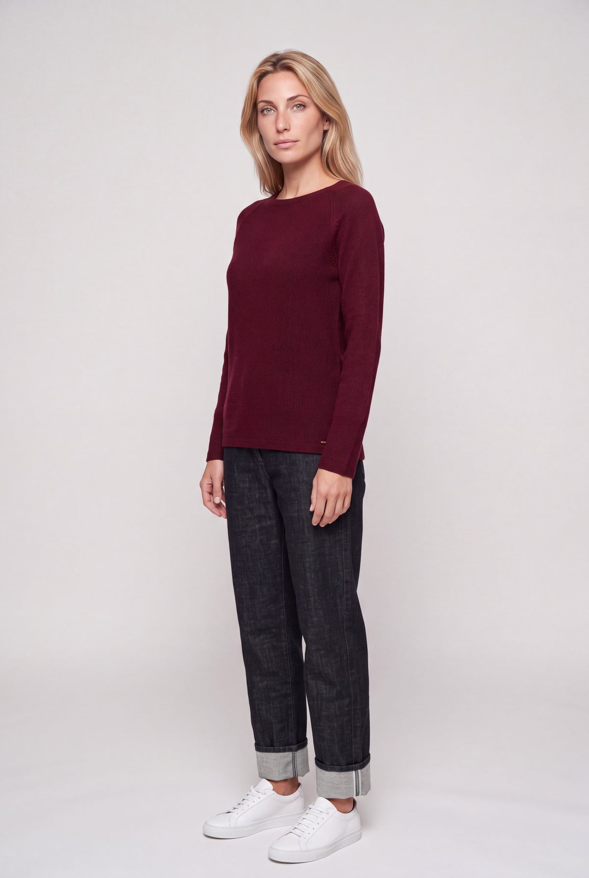Maglia girocollo donna in punto riso color bordeaux con manica raglan, indossata con jeans scuri
